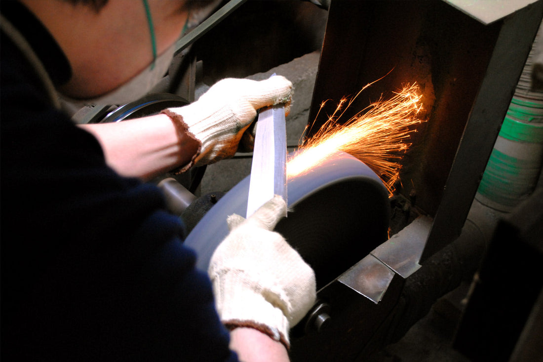 Bladesmith forging a Japanese knife over a forge fire