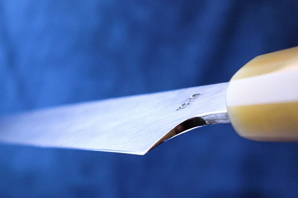 Close-up of a yanagi knife blade showing the concave uraoshi edge