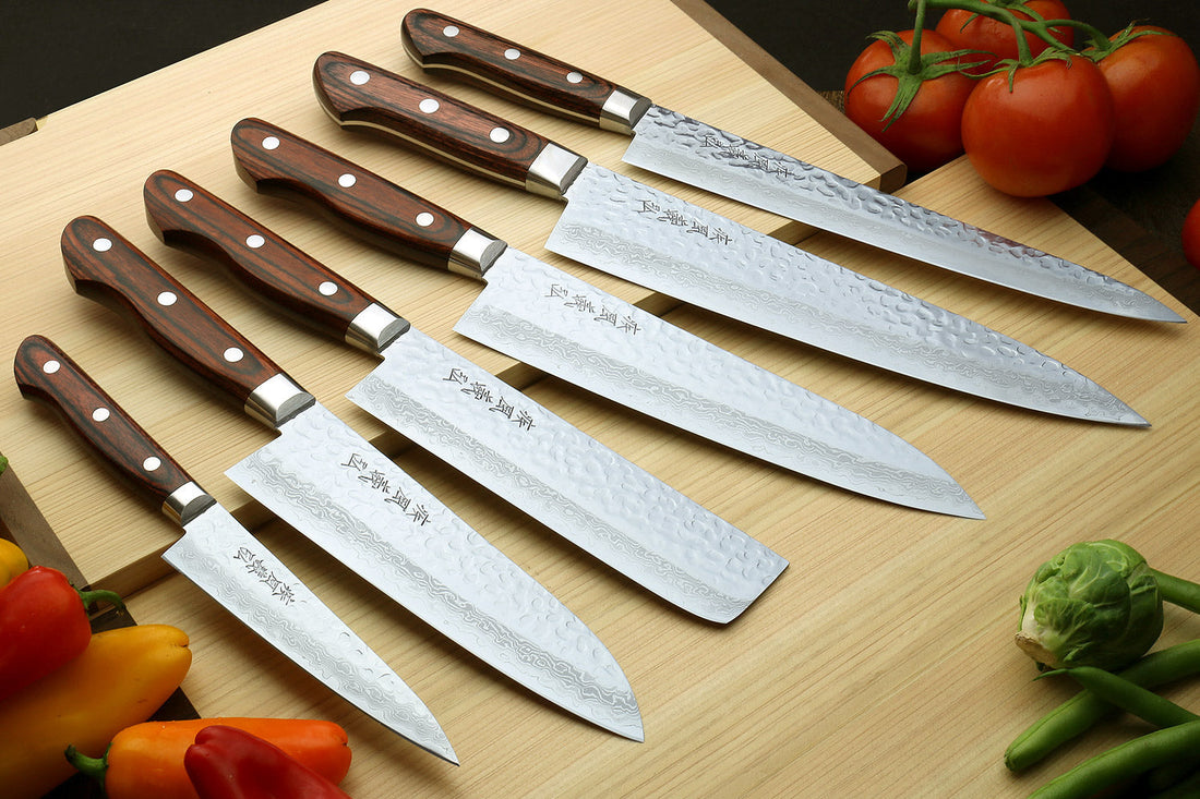 Japanese Damascus chef's knife set next to a Western-style chef's knife