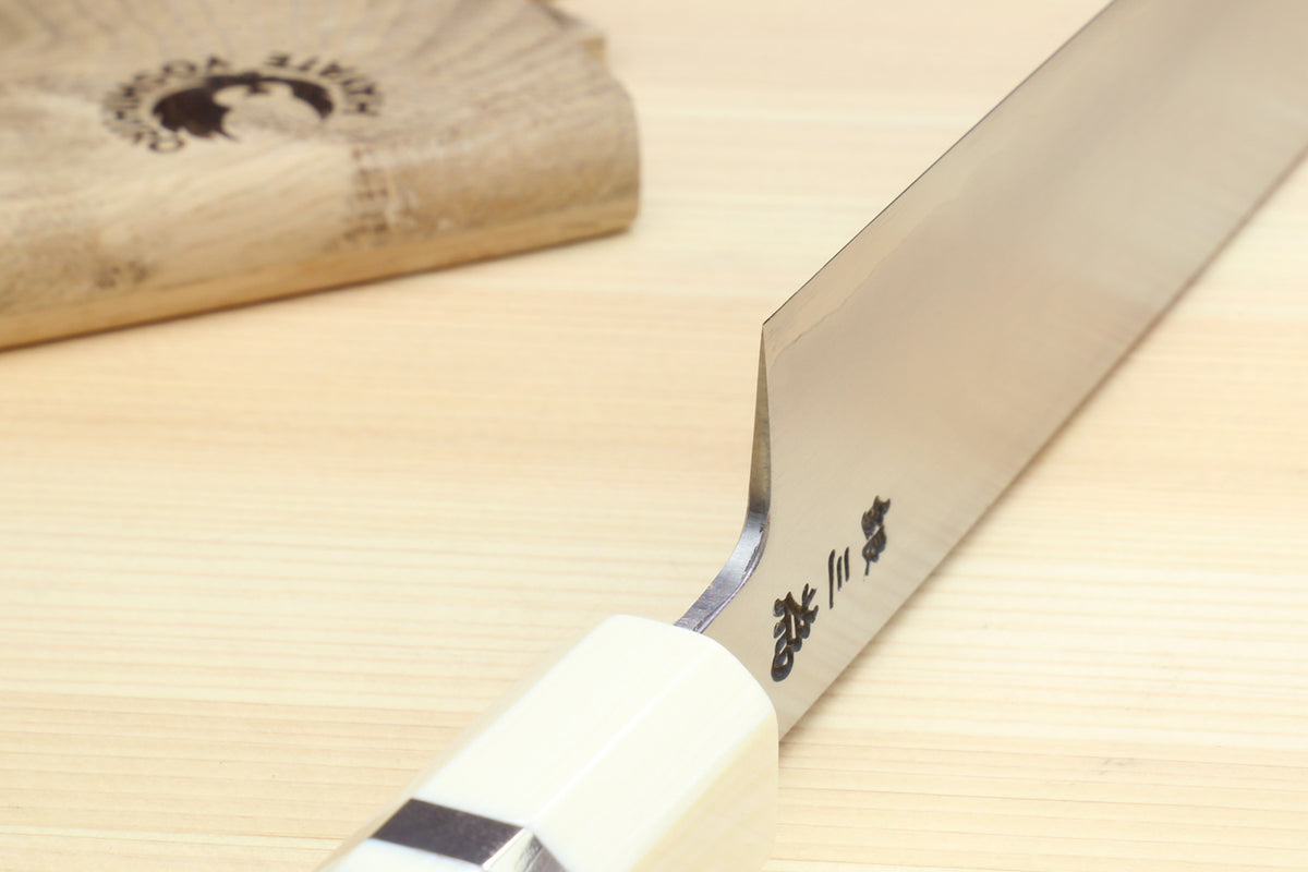 Sujihiki slicer knife close-up of blade markings and edge beside blue stabilized handle