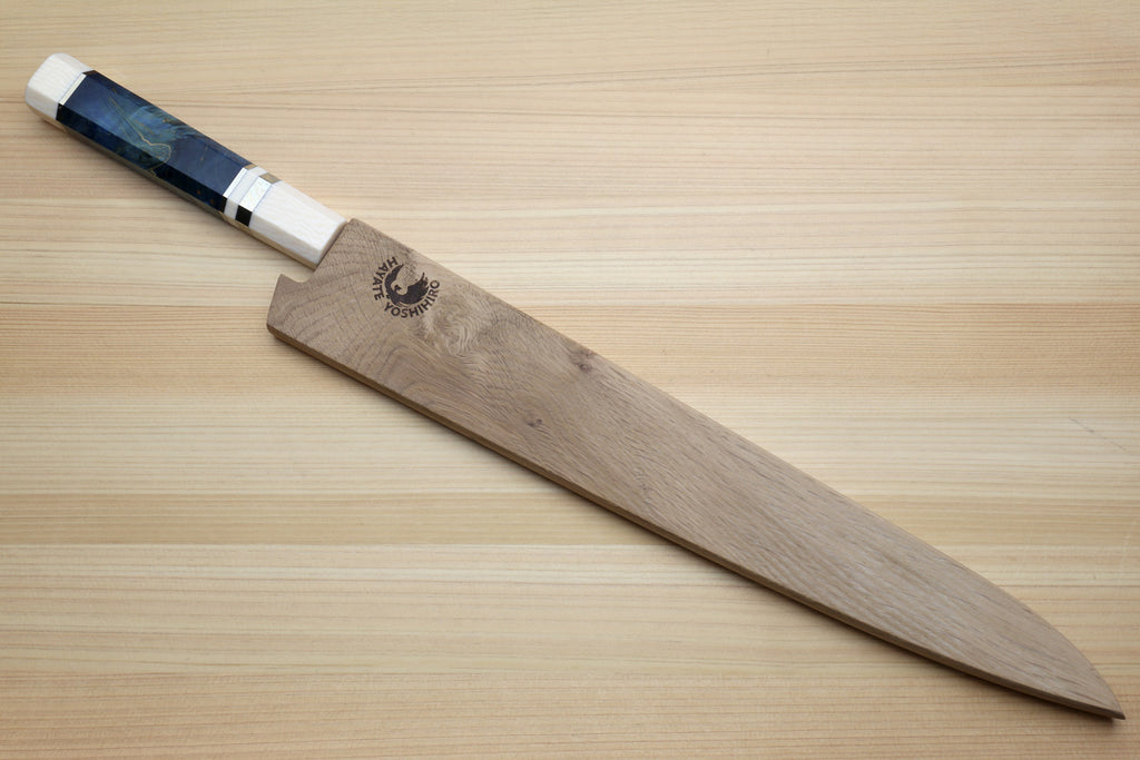 A Japanese-style kitchen knife with a wooden handle and a dark blue marbled handle inlay, resting diagonally on a light wood grain surface. The handle features a black dragon logo.
