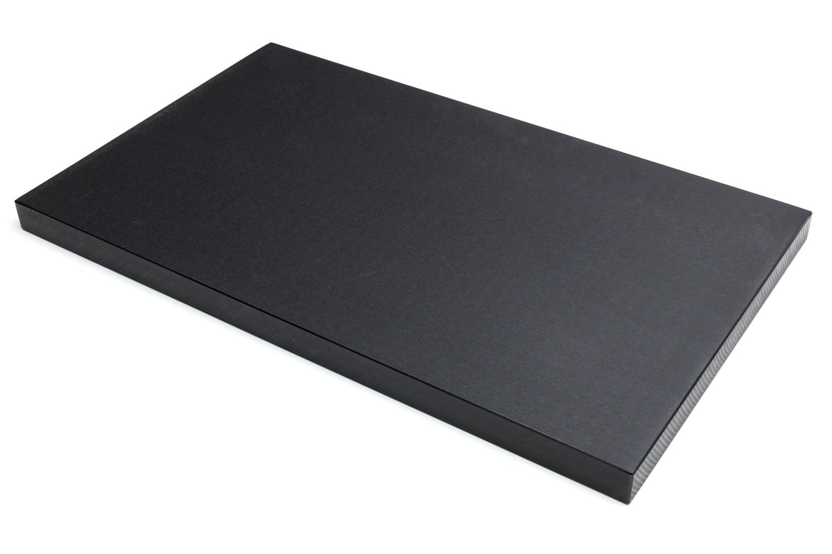 Black soft cutting board, flat rectangle shown at an angle on white