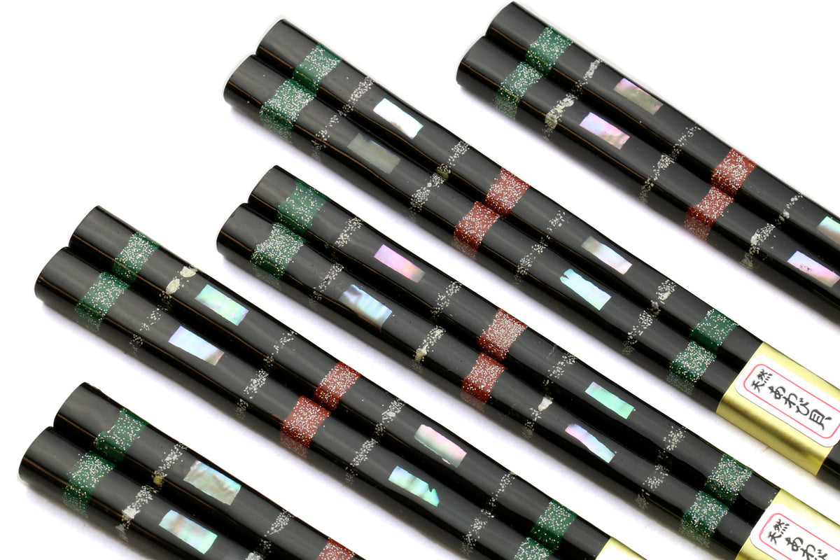 Five black chopsticks with green and red mosaic bands along the center