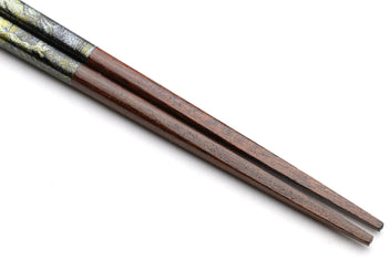 Pair of lacquered wooden chopsticks, dark marble pattern, shown at the tips