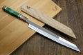 Traditional Japanese knife with wooden sheath on a wooden surface