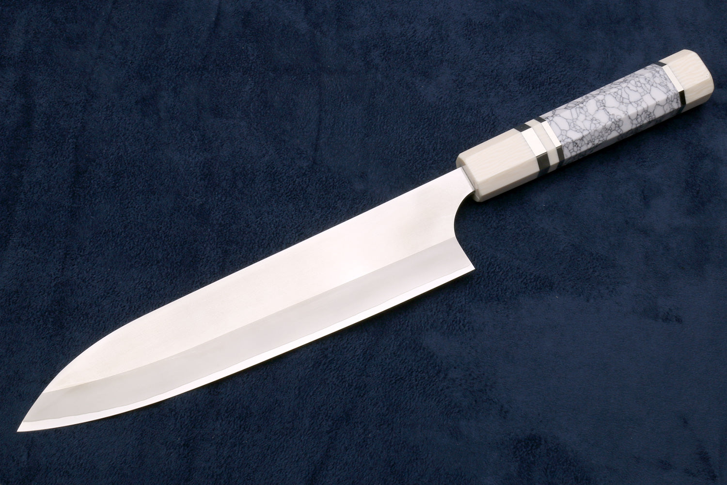 Shiny knife with a decorative handle on a dark blue background