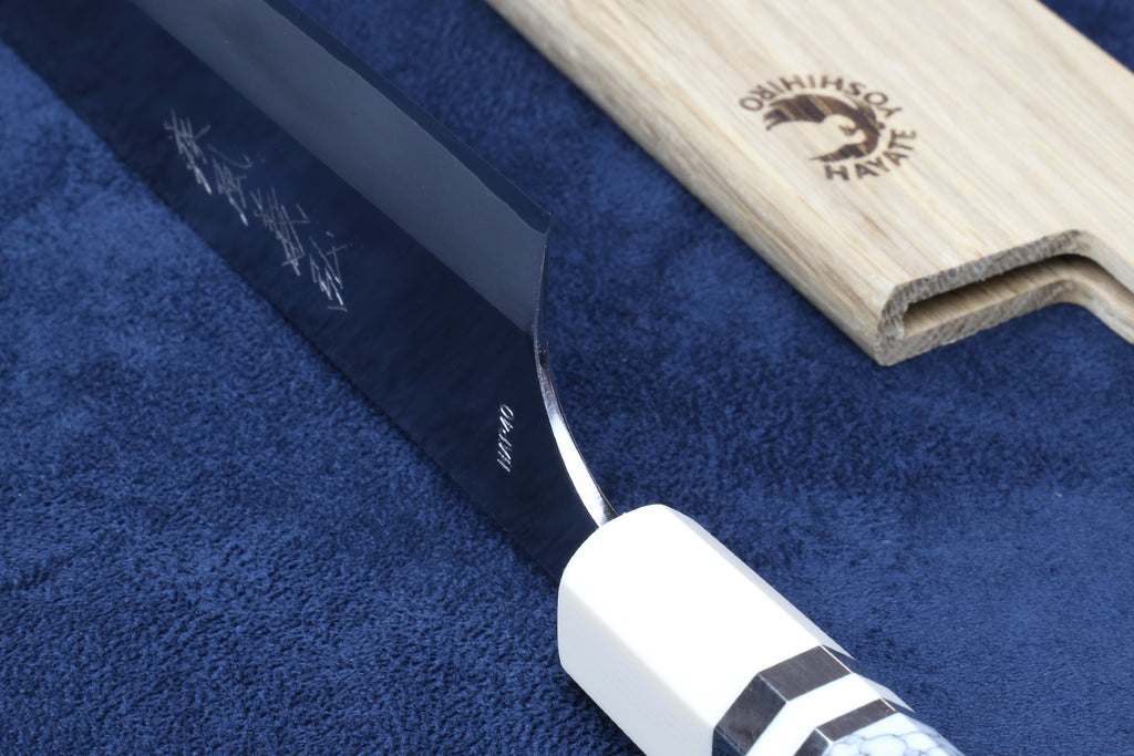 Knife heel shown on blue background with saya cover next to it