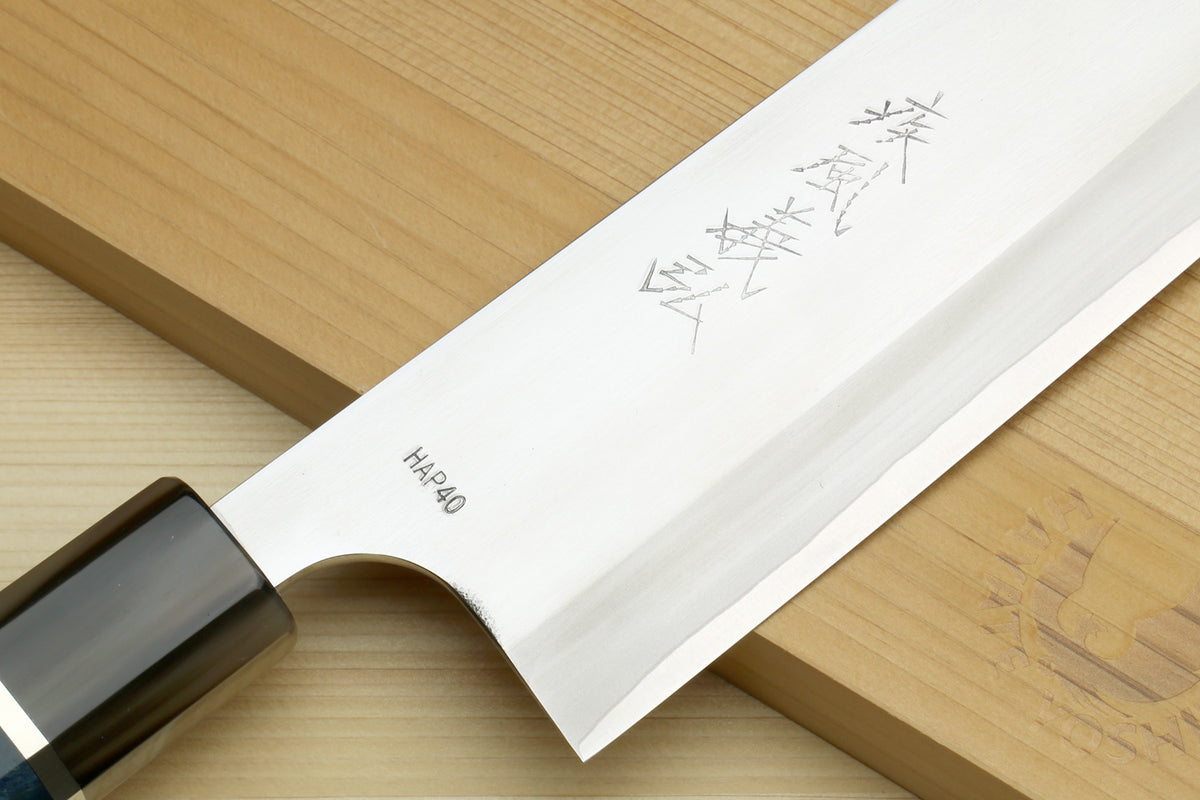 Santoku chef's knife showing stamped HAP40 mark on white blade and blue handle