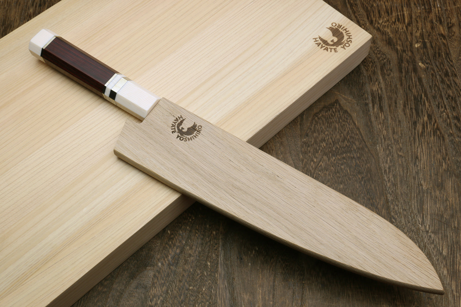 A chef's knife with a light wood blade and a dark brown handle, resting diagonally on a matching light wood cutting board. The brand name 'Omni Knife Company' is engraved on both the blade and the board, set against a dark wood background.
