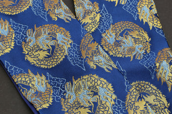 Blue fabric with repeating gold dragon medallion pattern, close-up on pouch