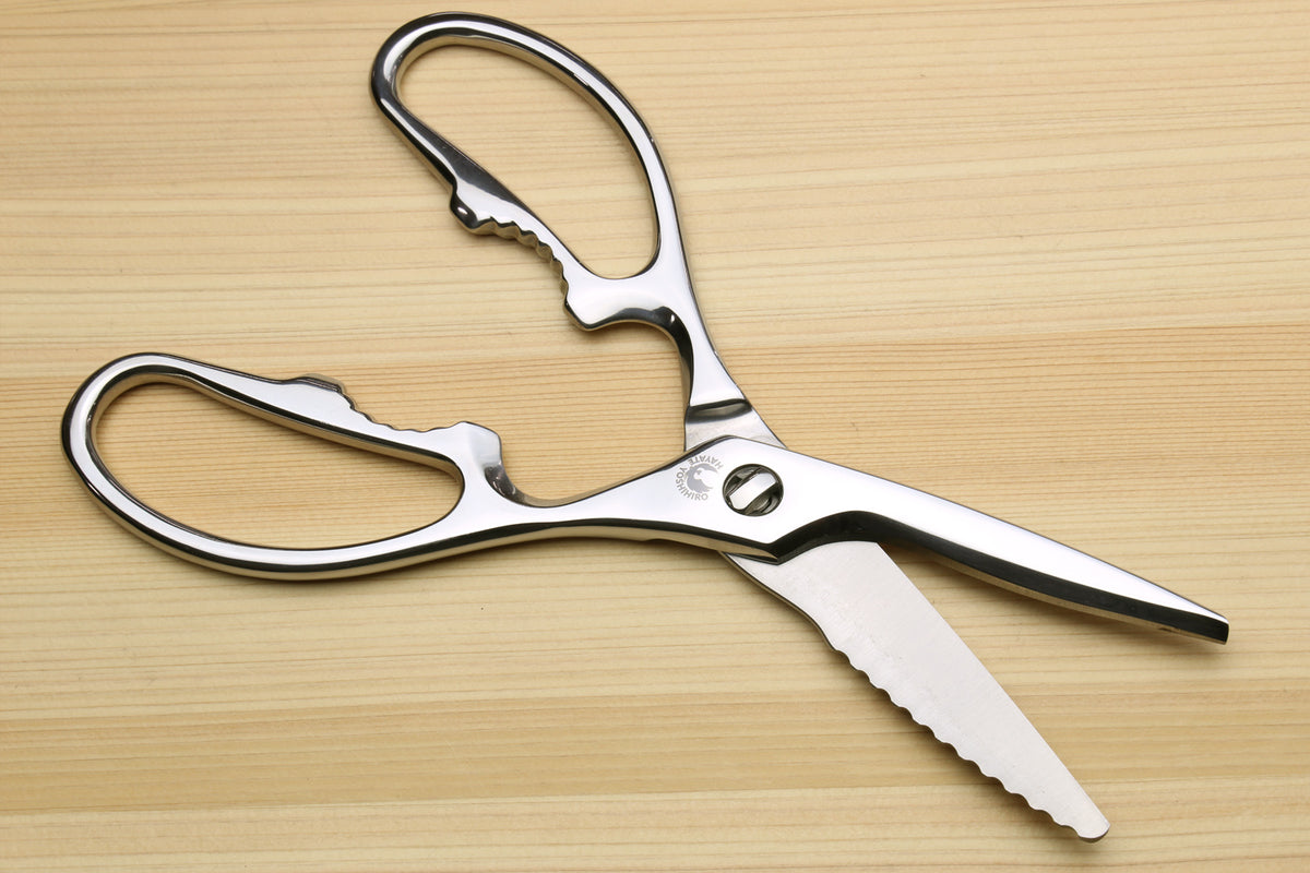Stainless steel kitchen shears with serrated blade tips and oval loop handles.