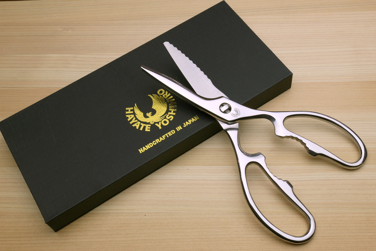 Stainless steel Japanese kitchen shears with serrated blades beside Yoshihiro box.
