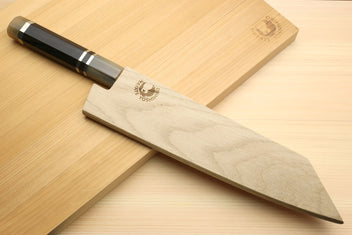 Kiritsuke chef's knife with octagonal ebony handle and wavy damascus blade on board