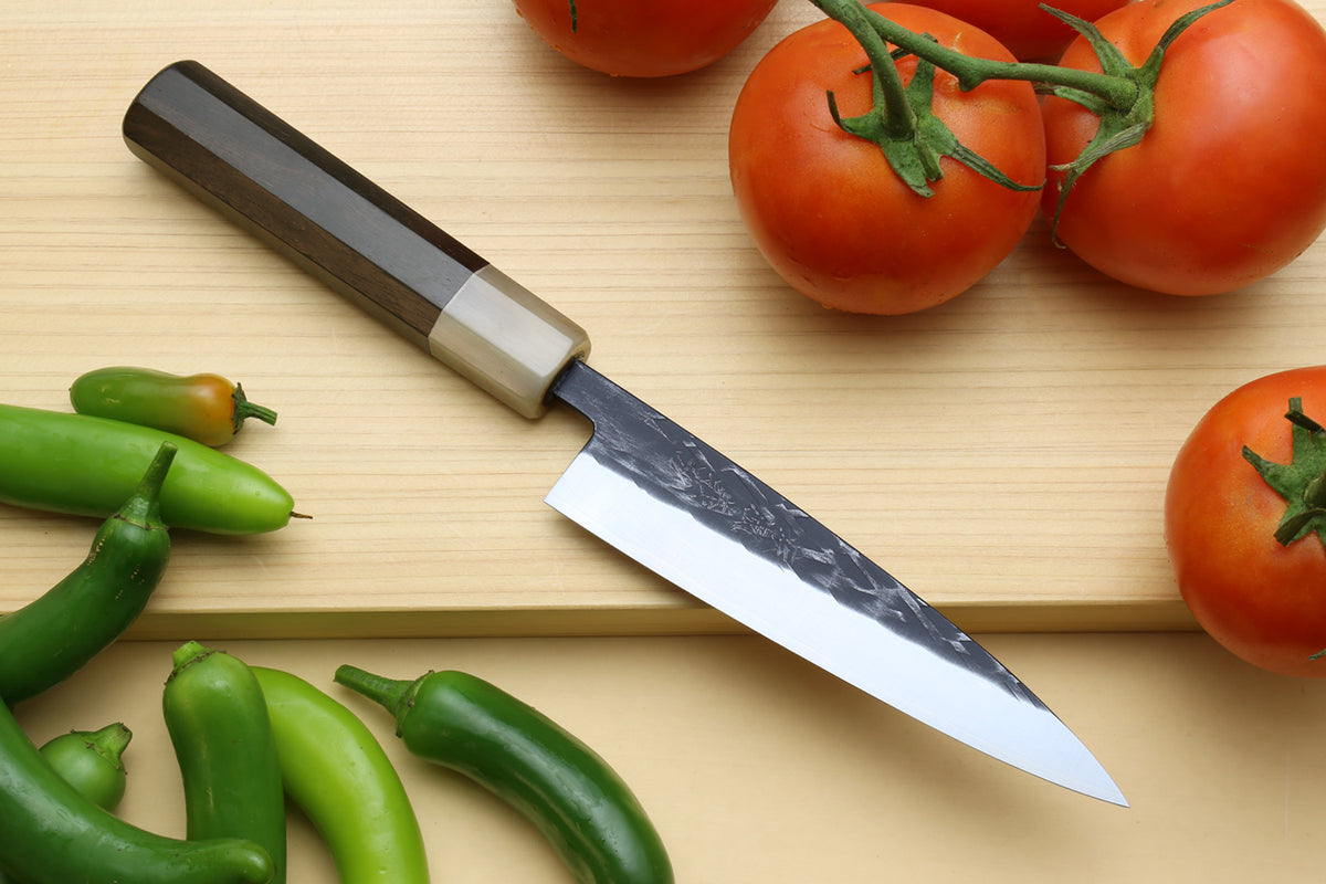 Nakiri and petty knives with black handles, dark patterned blades, pointed tips