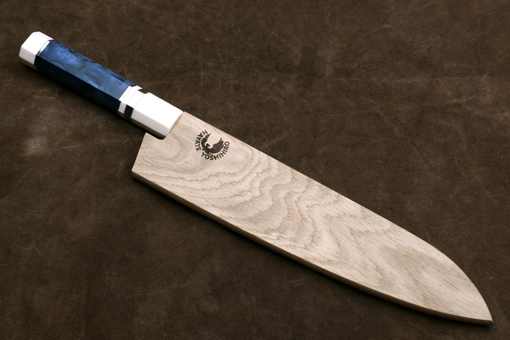 Chef's knife with blue handle stored in a wooden sheath on a brown leather background