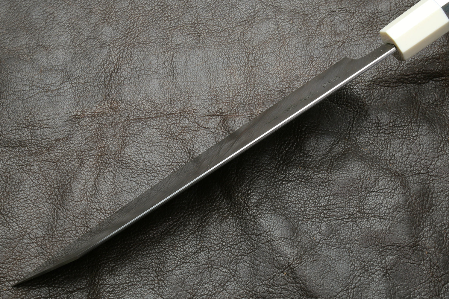 Knife spine with a dark leather surface