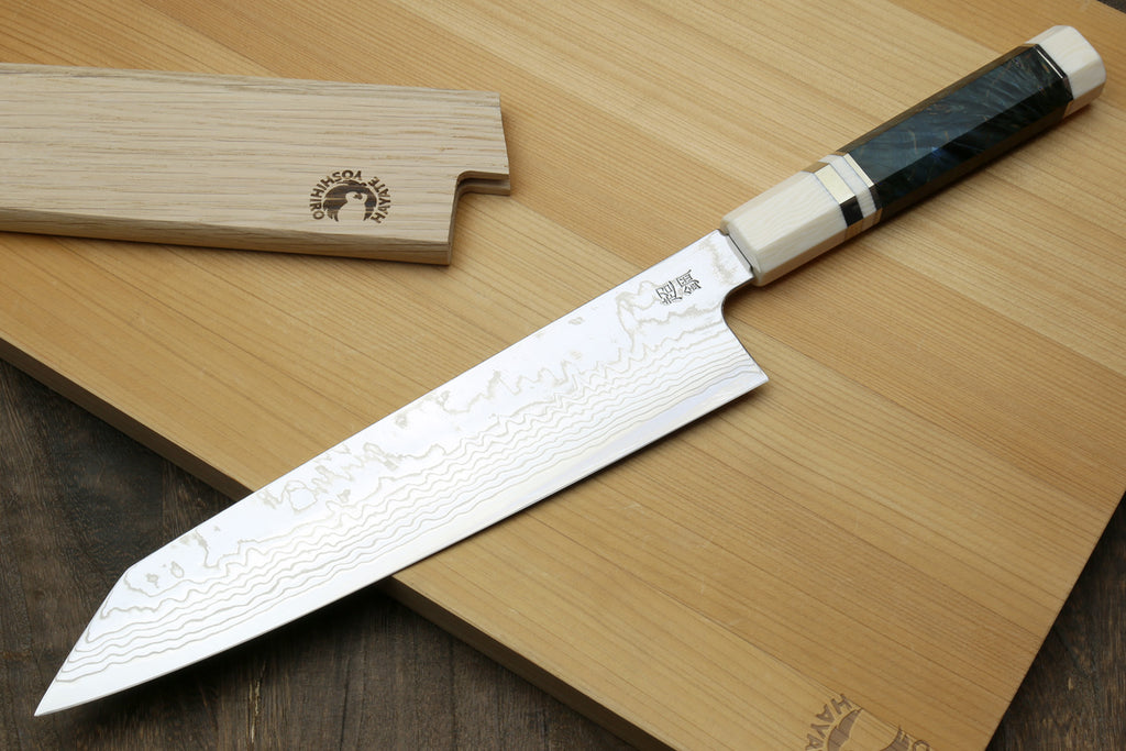 back side of ZDP189 damascus knife, accompanied by a wooden sheath on a wooden cutting board