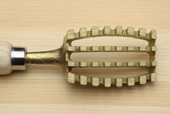 Fish scaler tool with gold metal head featuring multiple rows of teeth