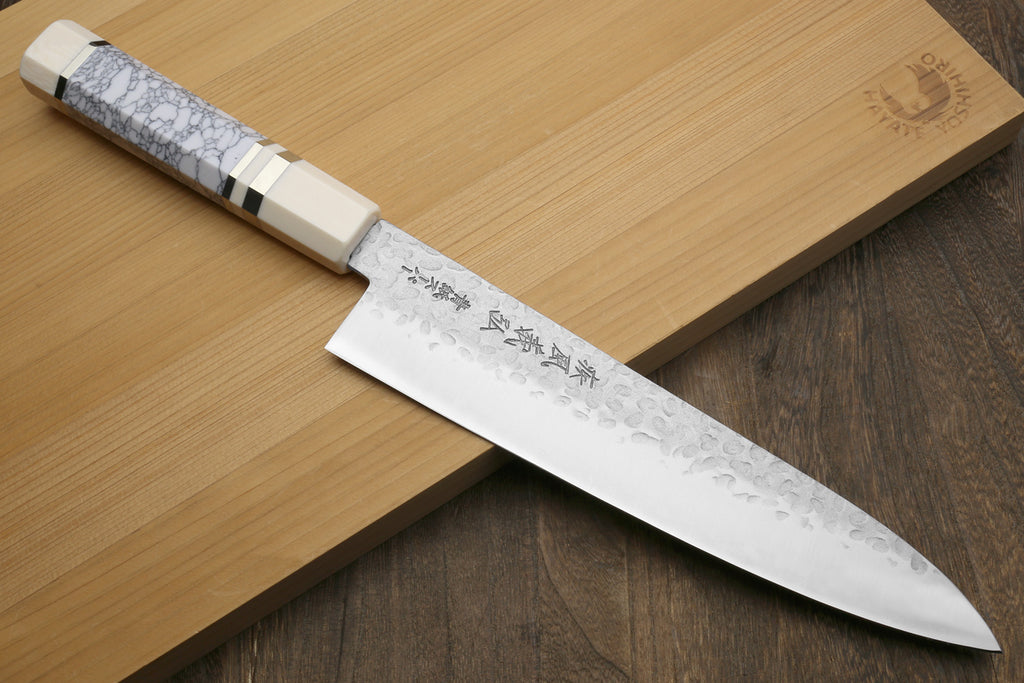 Chef's gyuto knife with pointed hammered blade and white crackle-pattern handle