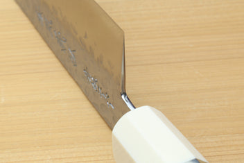Chef's gyuto knife with white handle and hammered stainless blade edge detail