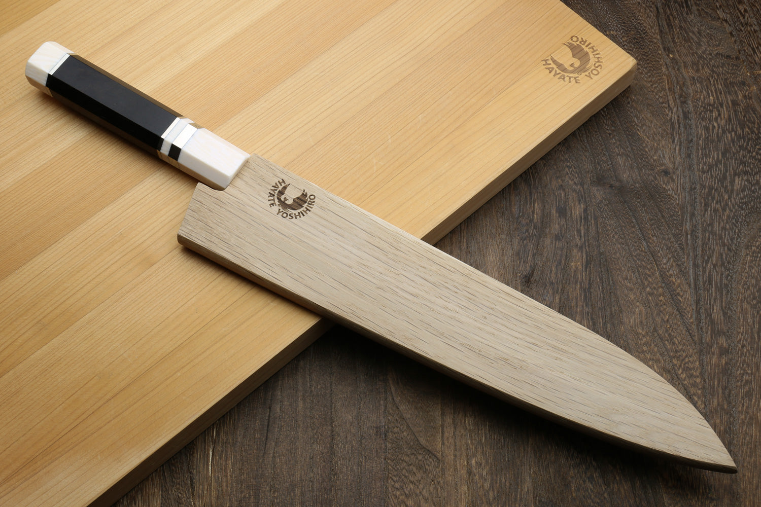 knife with ebony wood handle stored in a wooden sheath on a light wooden cutting board