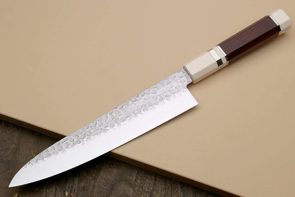 Chef's gyuto knife angled view: hammered stainless blade, rosewood handle, ivory bolster
