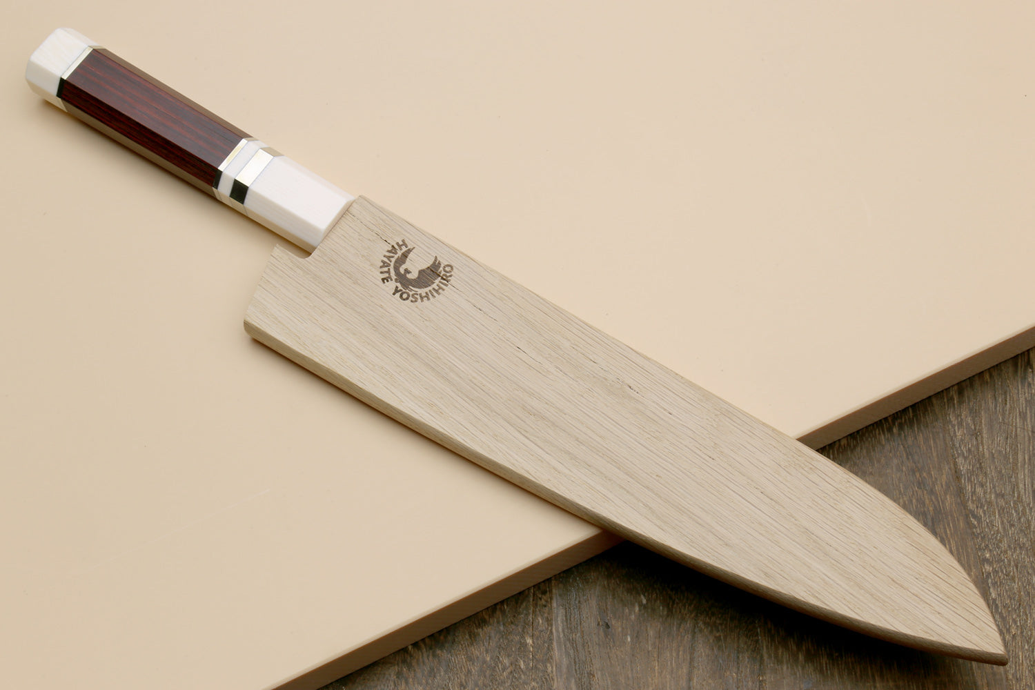 Chef's gyuto knife top view with hammered stainless blade, rosewood handle, ivory bolster