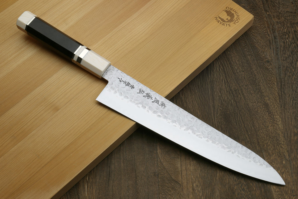 Japanese chef's knife with ebony wood handle on a wooden cutting board