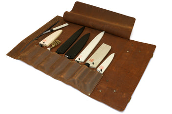 Brown leather knife roll case open with multiple knives secured in slots