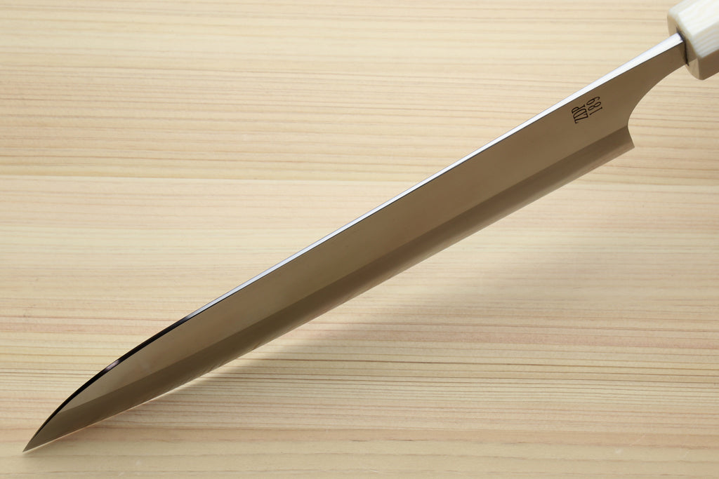 A stainless steel kitchen knife with a white handle, shown diagonally on a light wood grain surface.