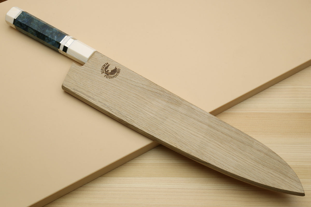 Gyuto chef's knife partly covered by a fitted wooden sheath