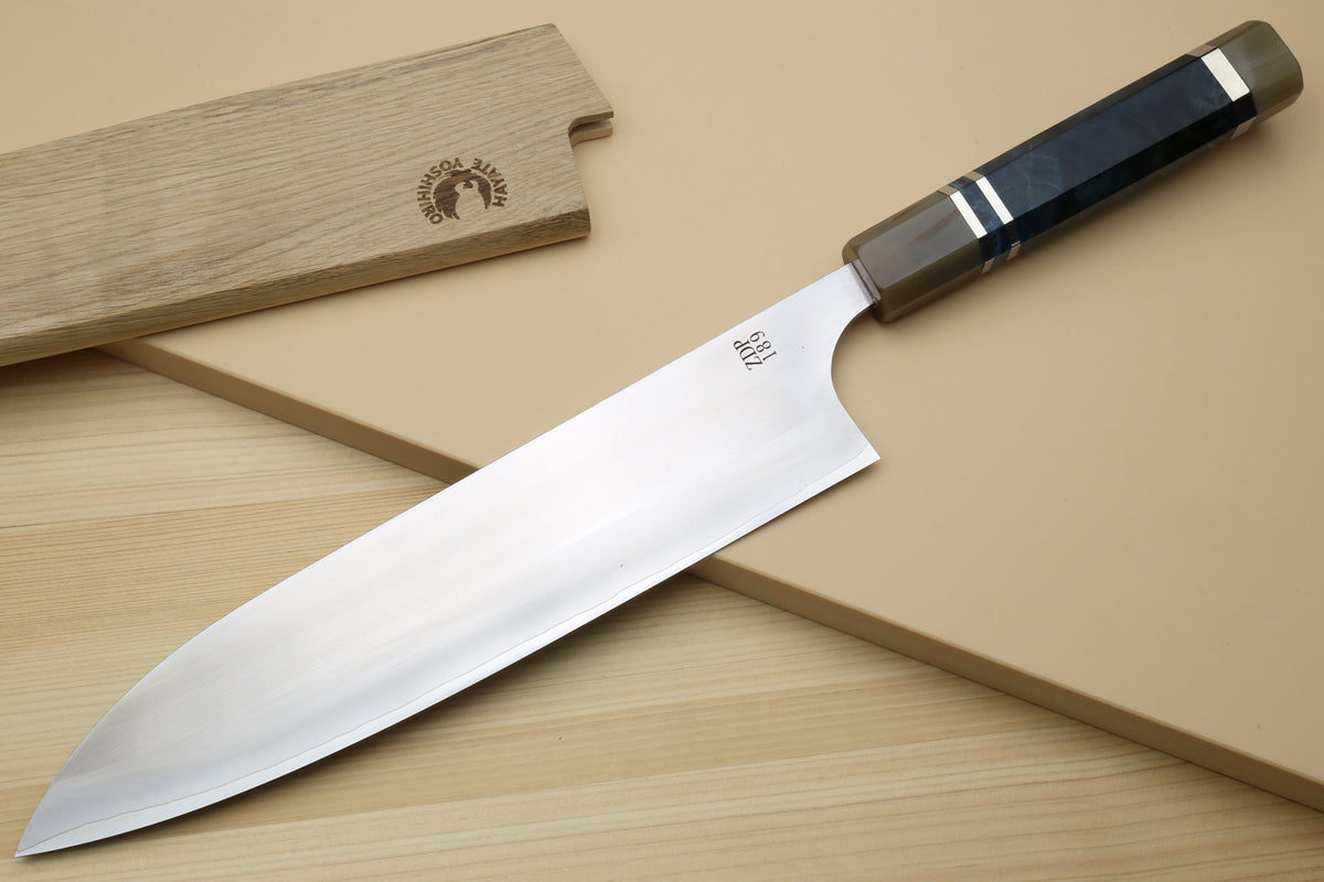 Gyuto chef's knife, showing broad polished blade and blue triple-ring handle