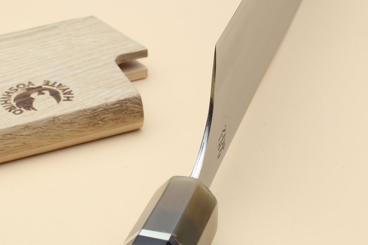 Yoshihiro Hayate knife close-up of blade spine and handle junction beside wooden sheath