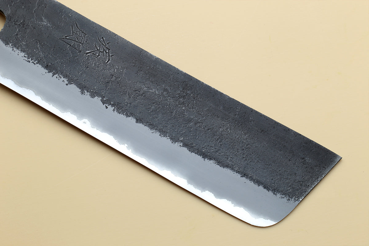 Nakiri vegetable knife blade tip and edge view with dark forged texture and silver bevel