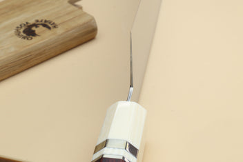 Chef knife bolster close-up with ivory grip and rosewood handle