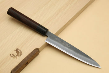 Kurouchi-finish gyuto chef knife with dark handle and engraved gray steel blade