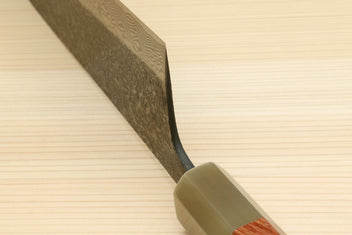 Santoku knife with ironwood handle and dark Damascus blade near bolster