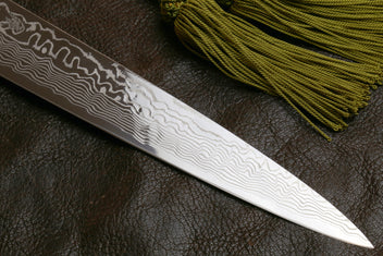 Sujihiki slicer knife blade, white-gray damascus finish along dark spine