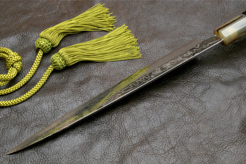 Sujihiki slicer knife with damascus steel blade and triple-ring dark handle, back view