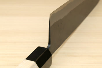 Gyuto knife with light wood handle and black sheath cover over the blade heel