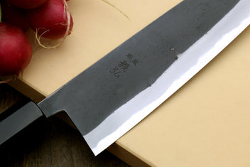 Santoku knife close-up of dark blade with etched markings and shiny edge