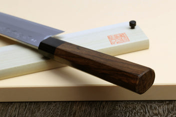 Japanese vegetable cleaver knife, blue steel blade with rosewood handle on light saya