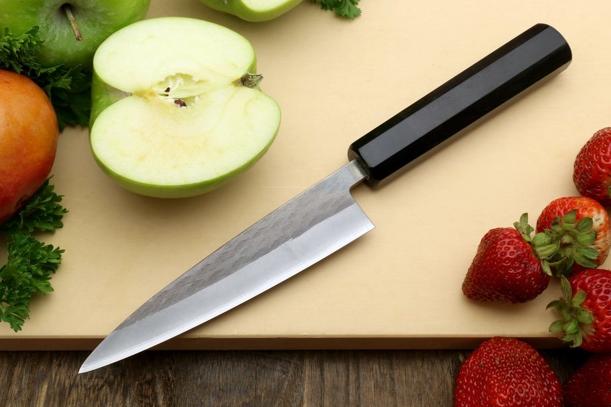 Petty utility knife with dark ebony handle and stainless blade, angled view
