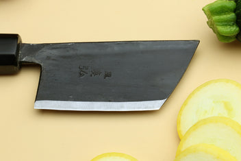 Paring knife with dark blade and camphor wood handle.
