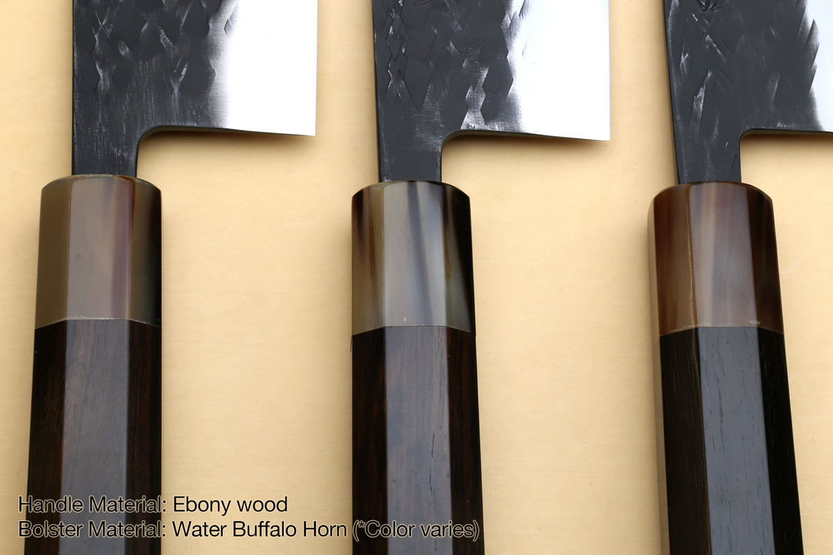 Knife handles close-up with black grips, bronze-gray bolsters, and dark accents