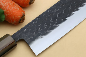 Nakiri vegetable knife blade close-up with dark hammered texture and white steel edge
