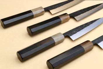 Set of 4 petty utility knives with dark handles and gray patterned blades