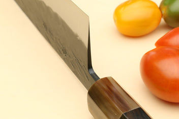 Santoku knife close-up: stainless blade with dark wood handle
