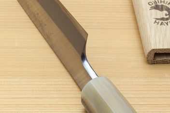 Yanagiba knife close-up of white steel blade and curved bolster near edge