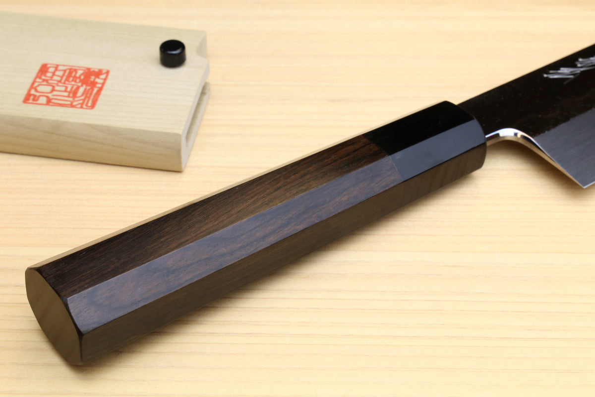 Japanese vegetable knife handle and heel detail with dark ebony grip on wood